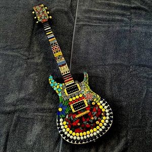 Les Paul guitar with decorative mosaic artwork.